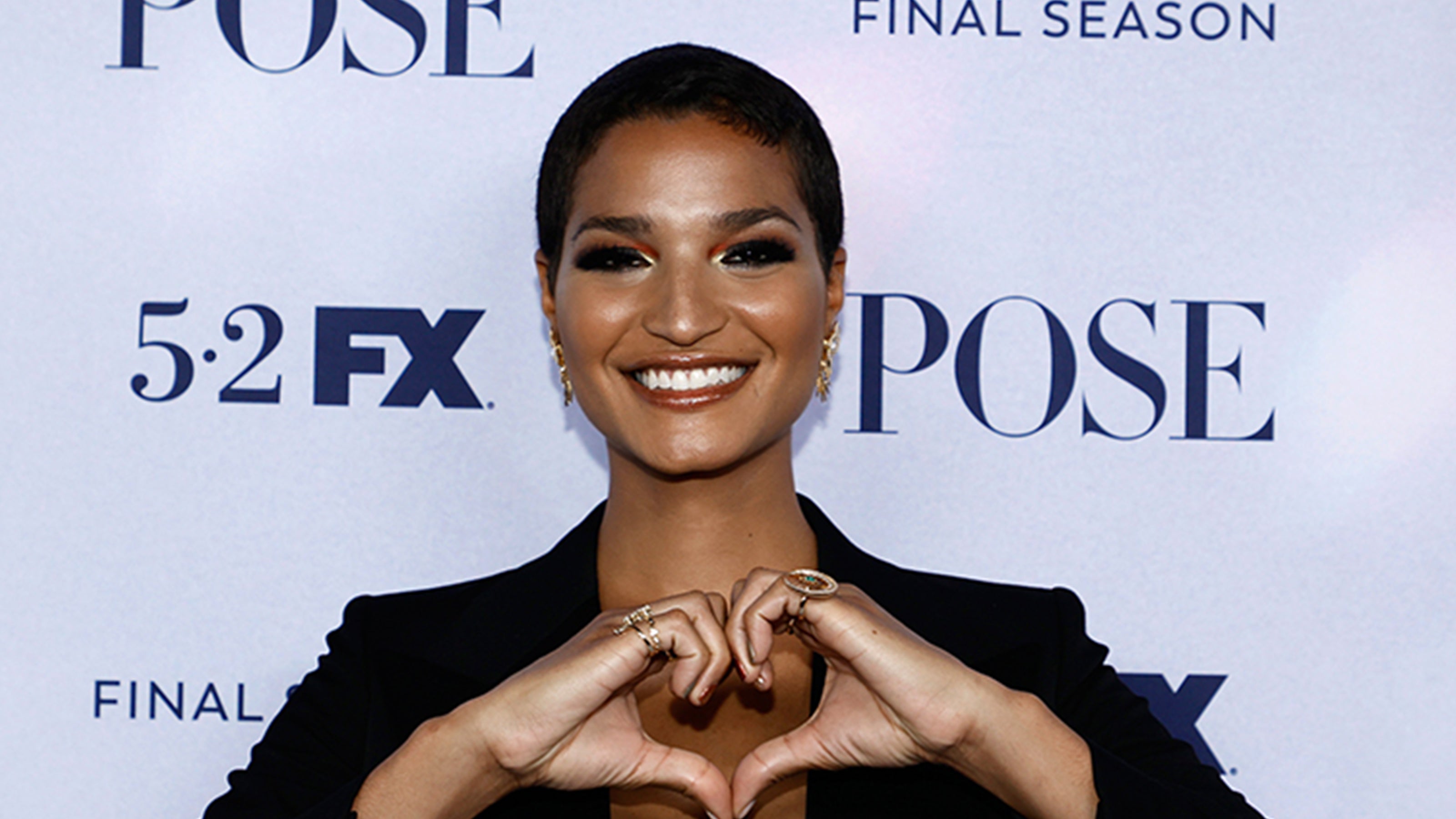 Indya-Moore-Colours-of-Love-Crescent-Ring-with-Gemfields'-Emerald-and-Colours-of-Love-Hilal-Ring-with-Gemfields'-Emerald-Pose-Season-3-premier