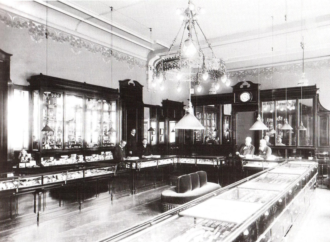 Vintage interior of a jewellery store with glass display cases and chandeliers.