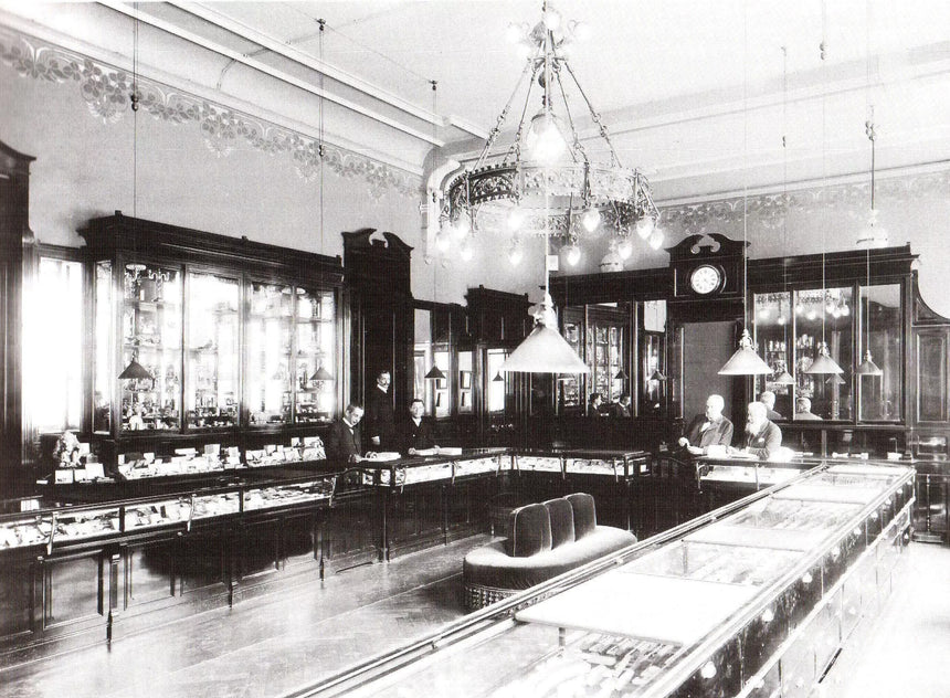 Vintage interior of a jewellery store with glass display cases and chandeliers.