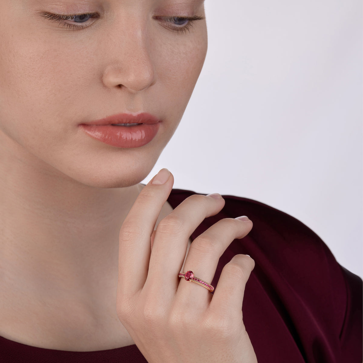 Love by Fabergé Ruby Pavé Ring -elegant rose gold ring featuring a vivid ruby centre stone with pavé-set rubies along the band, styled against rich burgundy silk